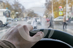 Man`s hand on the steering wheel of the car
