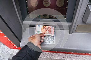 Man's hand takes out cash euros from Santander Bank