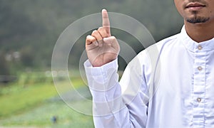 A man`s hand with a tauhid symbol on blur background