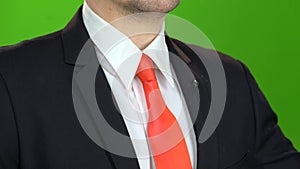 Man`s hand tightens the necktie under his neck. Green screen. Close up