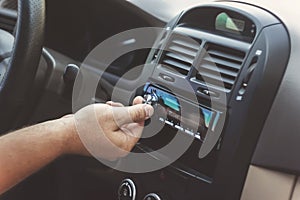 man's hand twists the volume in a retro toning car