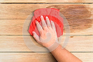 A man`s hand Using red rags wipe the wooden floor