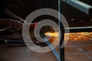 A man`s hand is using a steel cutter to make a spark table structure