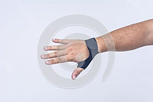 A man's hand wearing an ultra-thin compression wrist and thumb brace for texting thumb syndrome, carpal tunnel or tendonitis