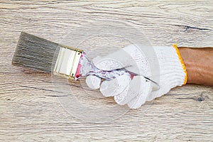 Man`s hand wearing white glove holding old grunge paintbrush on