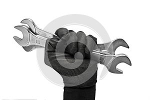 Man\'s hand in a work glove holds a spanners