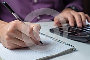 Man`s hands with calculator at the office and Financial data analyzing counting on white desk