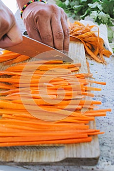 Man`s hands, cut carrot julienne style