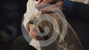 Man`s hands drumming out a beat on an arabic percussion drum named Bendir