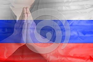 Man`s hands folded in prayer against the background of the Russian flag. Pray for Russia