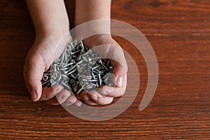 Man`s hands hold several screws.