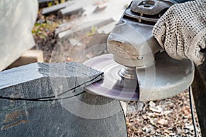 Man`s hands holding angle grinder and cutting  a stone