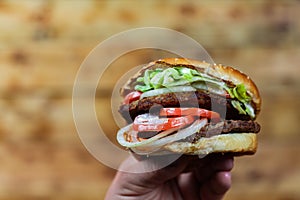 Man`s hands, holding onto a burger