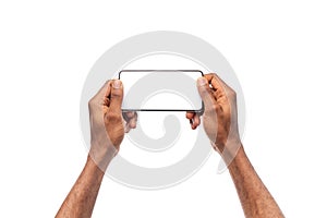 Man`s hands holding smartphone with blank screen, playing video games