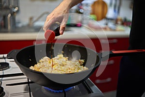 Man\'s hands making fried rice in a wok