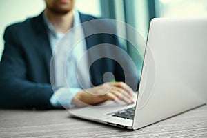 Man's hands on notebook computer, business person at workplace