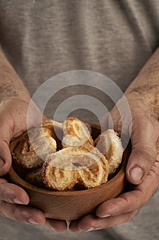 Man& x27;s hands offering puff pastry palmeritas orejitas photo