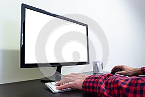 Man`s Hands on Office Computer on Wooden Black Desk Mockup. LCD Screen, Keyboard, Mouse. White Mug. Copy Space