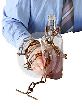 Man`s hands in old rusty chains near the bottle. Isolated on white background. Addicted to alcohol. In the trap of office work.