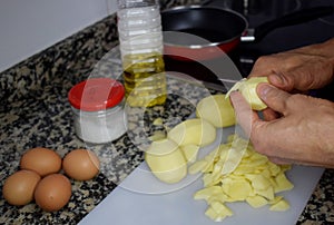Man`s hands peeling potatoes for cooking spanish omelette photo