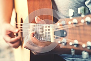 Man`s hands playing acoustic guitar