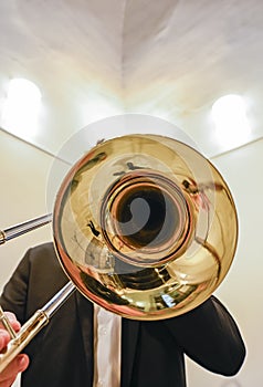 Man's hands playing the trombone in the orchestra.