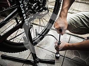 A man`s hands pumping up a bike tire