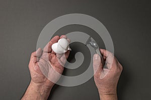 A man\'s hands with a razor and shaving foam on a gray background