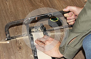 Man`s hands sawing the platband