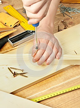 Man's hands screwing bolt