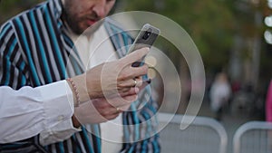 Man's hands showing something on his mobile phone to his family member