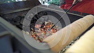 Man`s hands stirring coals for cooking outdoors