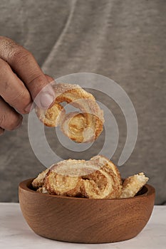 Man& x27;s hands taking puff pastry palmeritas orejitas photo