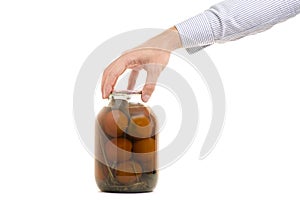 Man`s hands tomatoes in a jar
