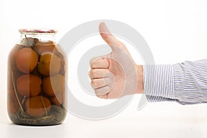 Man`s hands tomatoes in a jar