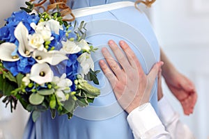 Man's hands touching stomach his pregnant woman