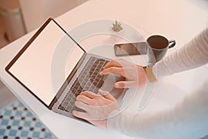 Man`s hands are typing or doing something on his laptop