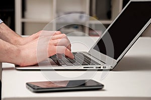 Man's hands typing on laptop