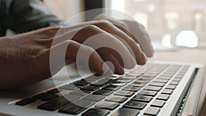 Man's hands typing on laptop keyboard