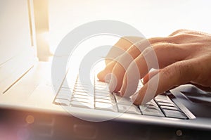 Mans hands typing on laptop keyboard photo