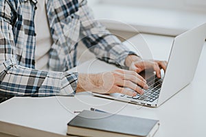 Man's hands typing on laptop keyboard