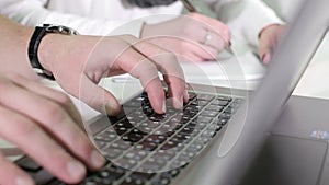 Man's hands typing on a laptop keyboard.
