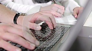Man's hands typing on a laptop keyboard.