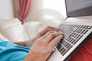 Man`s hands typing on laptop notebook keyboard at home. Man browsing information on internet. Freelance blogging, it