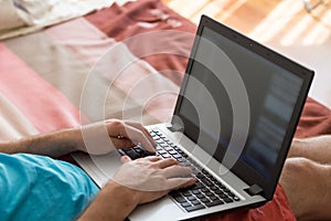 Man`s hands typing on laptop notebook keyboard at home. Man browsing information on internet. Freelance blogging, it