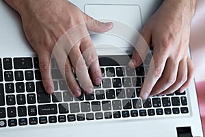 Man`s hands typing on laptop notebook keyboard at home. Man browsing information on internet. Freelance blogging, it