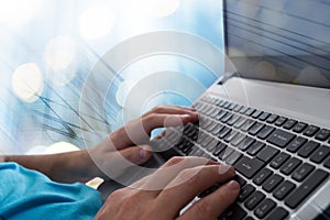 Man`s hands typing on laptop notebook keyboard in the office. Man browsing information on internet. Freelance blogging