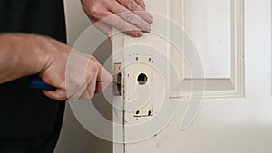 Man`s hands use rusty chisel for door lock hole