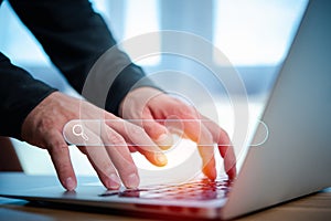 Man`s hands are using a computer notebook to Searching for information