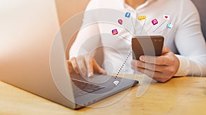 Man`s hands using smart phone and laptop in interior.